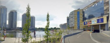 Kyiv, Ukrayna - 24 Temmuz 2021: Gökdelenler göletteki suya yansıtılır. Güneşli bir günde şehir. Şehir Parkı