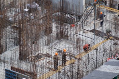 Yerleştirilmiş beton yapılara sahip inşaat alanı. İnşaat alanında beton işi. İnşaat işçileri inşaat için sıvı beton döküyorlar..