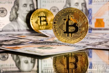 İçinde Benjamin Franklin 'in Amerikan dolarlarından bir portresi olan altın bitcoin. Bitcoin BTC sanal para ve Amerikan doları banknotları. Bitcoin kripto para ve Amerikan dolarına sahip arka plan
