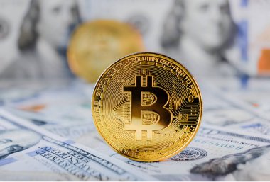 Dolarlar ve Bitcoinler birikti. Dolar banknotları üzerinde Bitcoin 'in sembolik sikkeleri. Bitcoin 'i bir dolara değişelim.