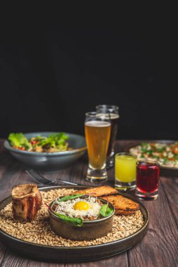 İki bardak bira, bir büyük patatesli gözleme ve siyah arkaplan üzerine sade ahşap masa üzerinde fırınlanmış kabak ile etli tartar servis edilir. Geleneksel tarif.