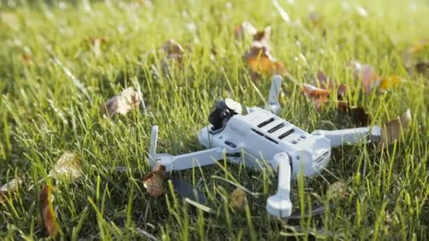 Drone after crash with broken camera module on green grass — Stock Video