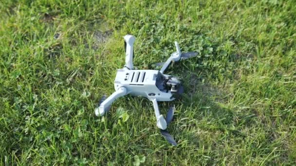 Una mano de mujer recoge un dron dañado del césped — Vídeos de Stock