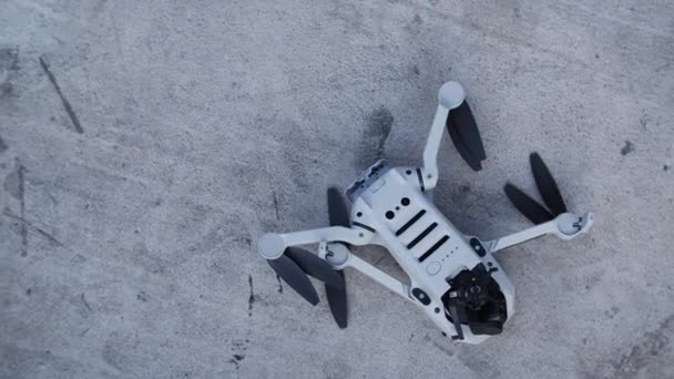 A damaged quadcopter on the grey concrete — Stock Video