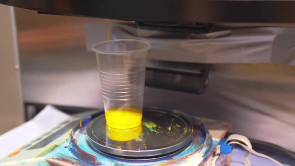 Process dosing of yellow colorant in a transparent container. — Stock Video