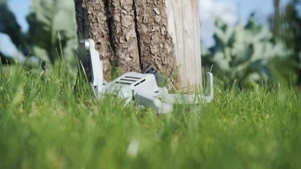 Una mano de hombre recoge un dron caído de un césped verde. DJI mini2 drone se estrelló. 09.12.2021 - Rusia, Orel — Vídeo de stock