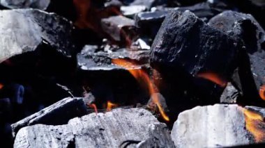 Kömürde ağır çekimde yanan turuncu ateş. Ağır çekimde kömür yanığı. Barbekü ızgarasında yanan kömürleri yakın. 4K görüntü