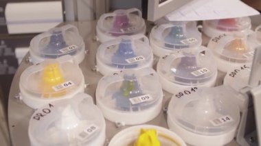 Otomatik dağıtıcı. Pigment yapıştırıcı kaplarının üst görünümü. Sarı boyalı tankı aç..