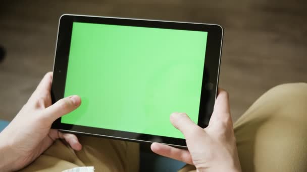 Młody facet gra na tablecie na symulatorze wyścigowym. Zielony ekran umożliwiający szybką wymianę wideo. Zbliżenie męskich dłoni z tabletem, widok z góry. Klip Wideo