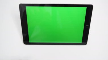 Bir adam yeşil ekranlı bir tabletteki çalma tuşuna basıyor. Sol ve sağ elin işaret parmağı Tablet-PC 'nizde videolar izlemeye başlar.