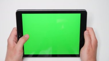 Yeşil maket ekranlı bir tablet bilgisayarı tutan elleri kapatın. Sosyal ağ ya da çevrimiçi mağaza için bir şablon. 4k görüntü