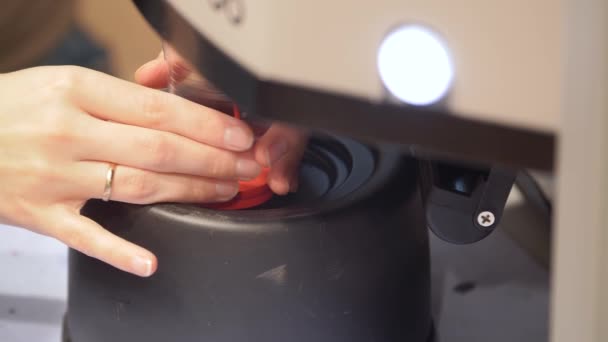 Werknemer schoonmaken van de dispenser mondstukken close-up. Vrouwen onderhouden een kleurmachine. Sluiten. Stockvideo
