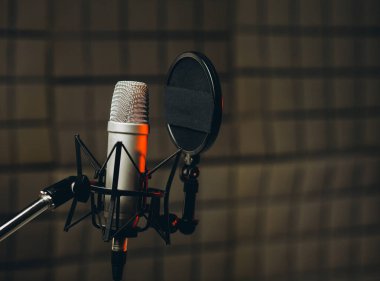 Ses kayıt stüdyosundaki seslendirme ve dublaj için profesyonel bir mikrofon görüntüsü. Kapat, podcast konsepti