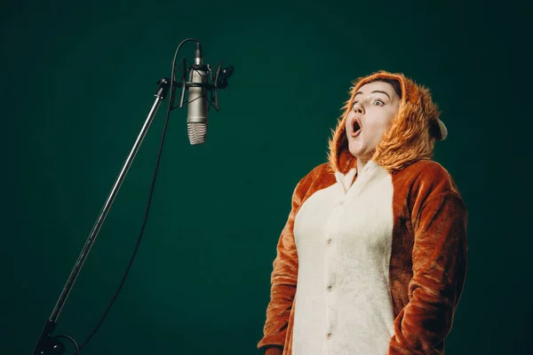 Woman prepares herself and a material before voice recording. Soundproof room for professional recording vocal. Voice artist works with material before dubbing or voice over process