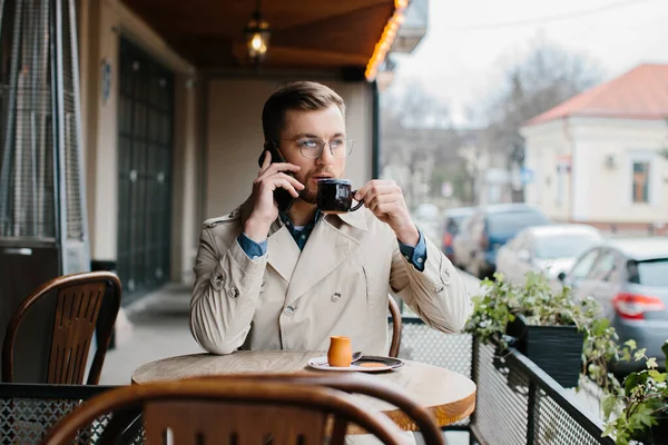 Genç Adam Kahve Içiyor Açık Bir Kafede Telefonla Konuşuyor — Stok fotoğraf