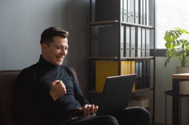 Heyecanlı adam Lapto 'ya bakarken jest yapıyor.