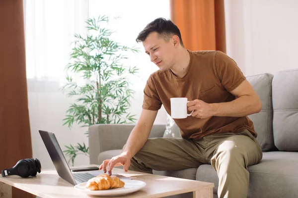 Hombre Sentado Sofá Bebiendo Café Usando Lapto —  Fotos de Stock