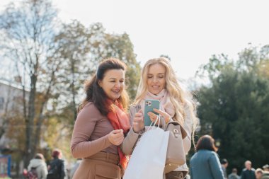 Son sınıf kız arkadaşları şehir sokaklarında dolaşırken alışverişi tartışıyorlar..