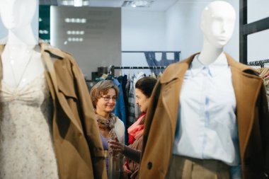 Yaşlı kadın müşteriler elbise dükkanından kıyafet seçerler..