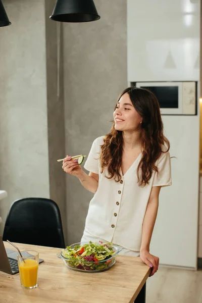 Young Woman Eating Salad While Sitting Kitchen Stock Photo — ストック写真