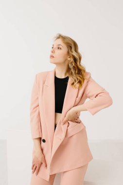 Beyaz arka planda modaya uygun pastel kıyafetli genç bir kadın.