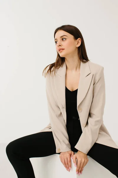 Jovem Mulher Moda Terno Pastel Sentado Cubo Contra Fundo Branco — Fotografia de Stock
