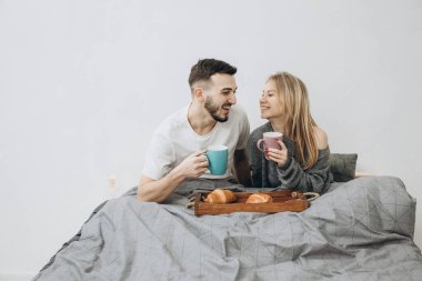 Romantik mutlu çift yatakta kahvaltı yapıyor.
