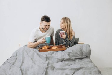 Romantik mutlu çift yatakta kahvaltı yapıyor.