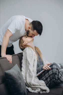 Aşık bir çift oturma odasındaki kanepede oturur, pijama giyer, sabah kalkar kalkmaz eğlenir ve kahvaltı eder.