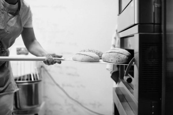 Female Baker Using Peel Take Out Loaf Bread Oven Bakery — Stock Photo, Image