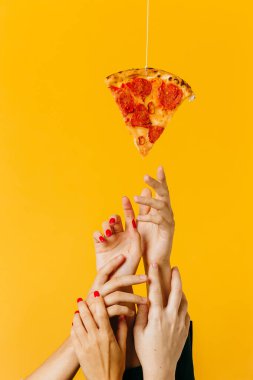 Creative concept advertising fast food. Hands reach for a piece of pizza.