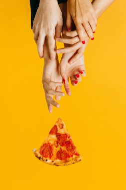 Creative concept advertising fast food. Hands reach for a piece of pizza.