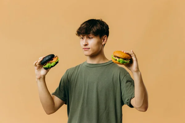 Jóképű Fiatalember Pózol Egy Hamburger Egy Színes Háttér — Stock Fotó