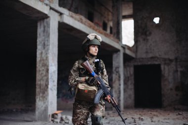 Yıkılmış bir binada elinde silahla Ukraynalı Kadın Asker. Ukrayna ve Rusya arasındaki savaş.