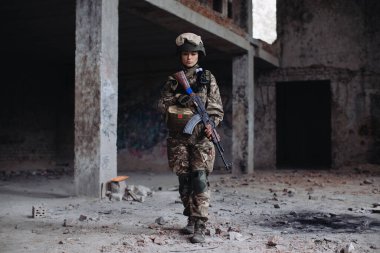 Yıkılmış bir binada elinde silahla Ukraynalı Kadın Asker. Ukrayna ve Rusya arasındaki savaş.