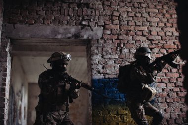 Ukraynalı askerler ellerinde bir silahla savaşıyorlardı. Ukrayna bayrağı bir tuğla duvara boyanmış. Ukrayna ile Rusya arasındaki ilişkiler