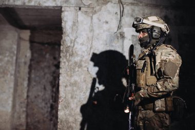 Yedek kulübesinde Ukraynalı bir savunucunun portresi. Elinde silah olan bir asker Duvara gölge düşürür.