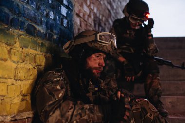 Silah arkadaşları Ukrayna bayrağının arka planında dinleniyor