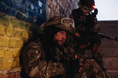 Silah arkadaşları Ukrayna bayrağının arka planında dinleniyor
