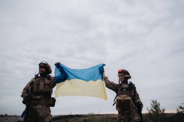 Ukrayna ordusu Ukrayna bayrağını elinde tutuyor. Zafer konsepti. Ukrayna ve Rusya arasındaki savaş.