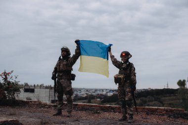 Ukrayna ordusu Ukrayna bayrağını elinde tutuyor. Zafer konsepti. Ukrayna ve Rusya arasındaki savaş.