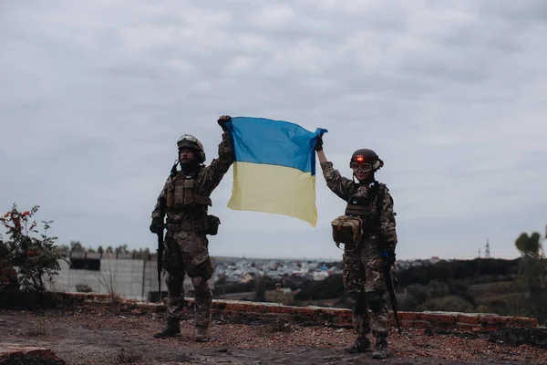 Ukrainian military holds the flag of Ukraine. The concept of victory. The war between Ukraine and Russia.