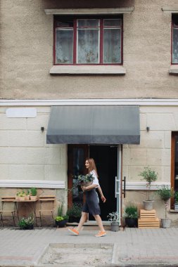 Çiçekçinin yanında sarmaşık olan çiçekçi kız..