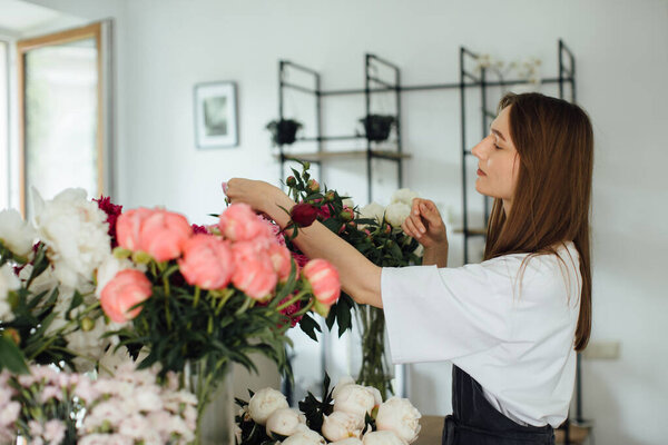 Florist woman in workspace of flower shop. - stock photo