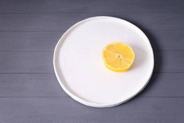 Gri ahşap bir masada el yapımı limon. Yağda yumurtaya benziyor.