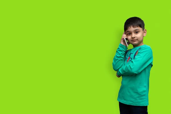 Söt Liten Pojke Grön Skjorta Talar Telefon Vanlig Bakgrund Med — Stockfoto