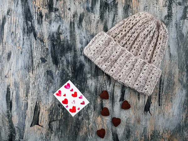Sombrero de punto de punto para una niña con una pequeña tarjeta con corazones — Foto de Stock