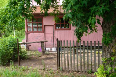 Yazın bir evi, ağaçları ve ahşap çiti olan eski bir avlu manzarası