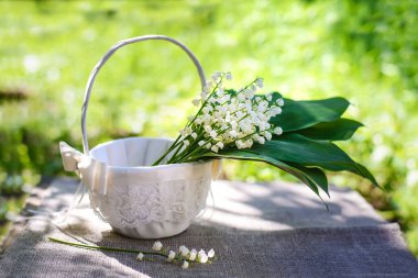 Beyaz dekoratif sepetin içinde bir demet nilüfer çiçeği.