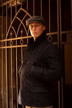 Paltolu ve şapkalı bir adam şehirde dolaşıyor..